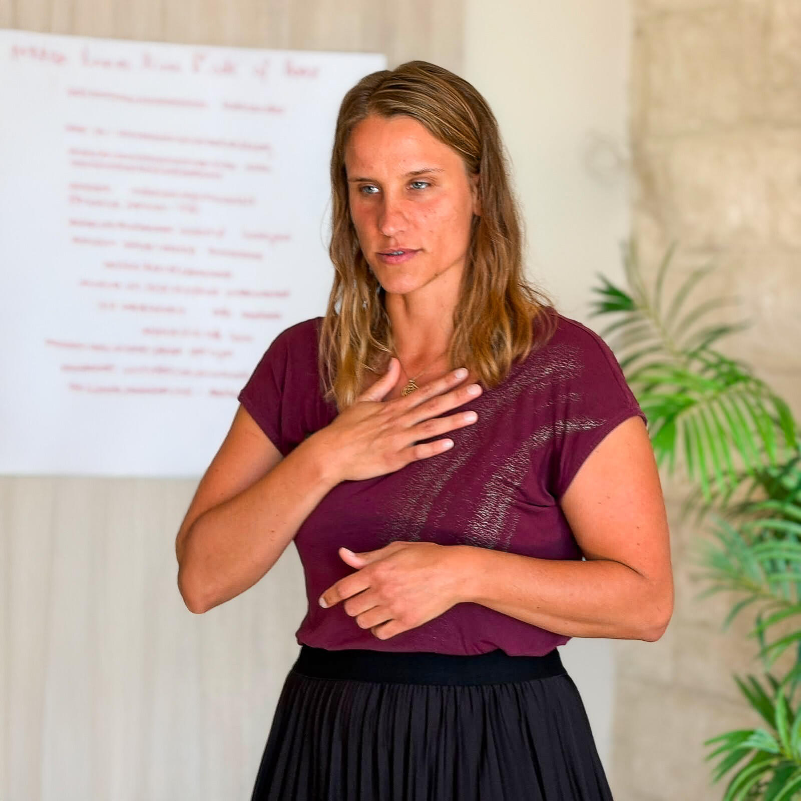 Daniela Kellner bei der Leitung eines Workshops mit einer Hand auf dem Herzen.